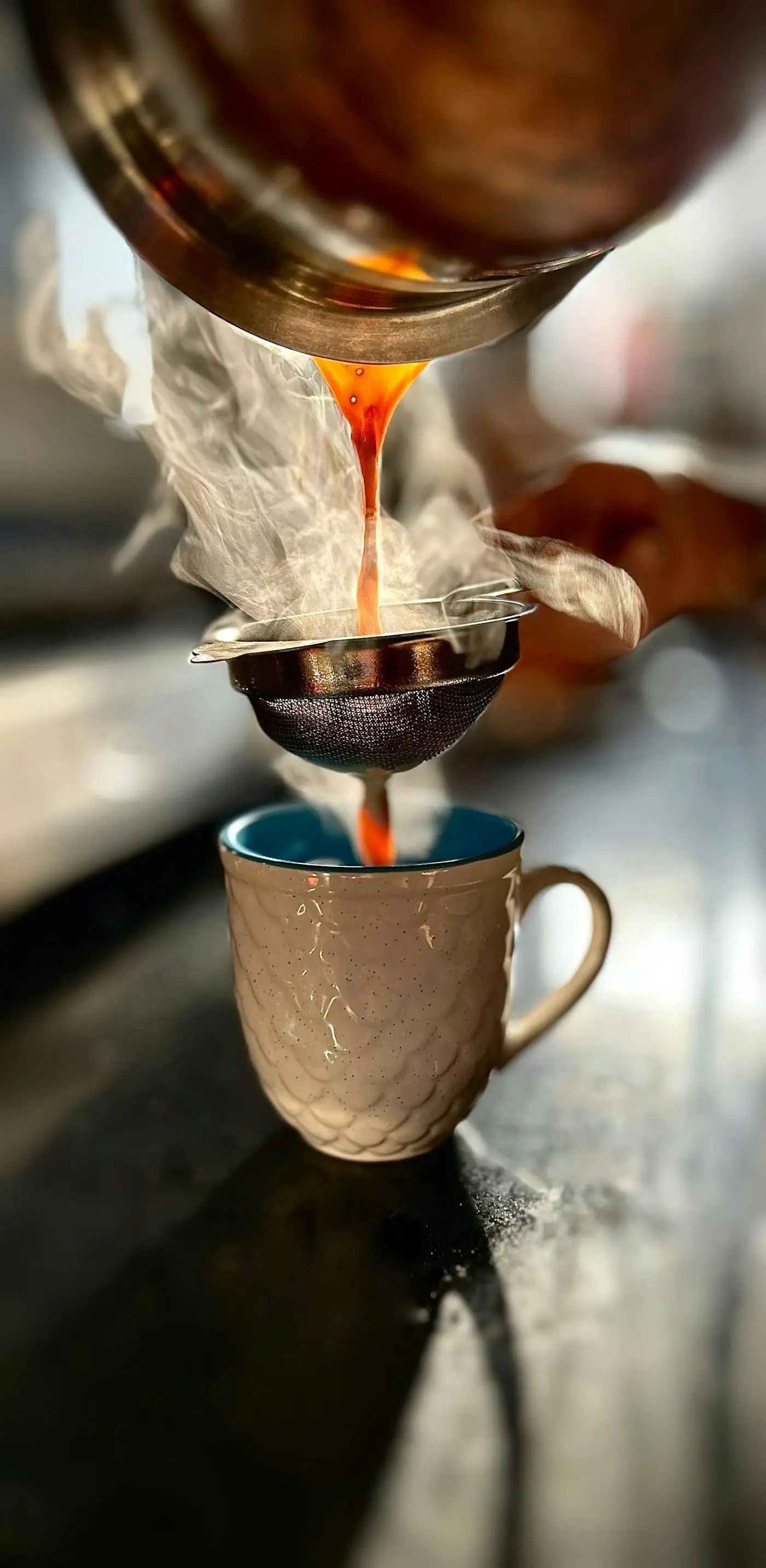 Hot masala chai being poured into a glass