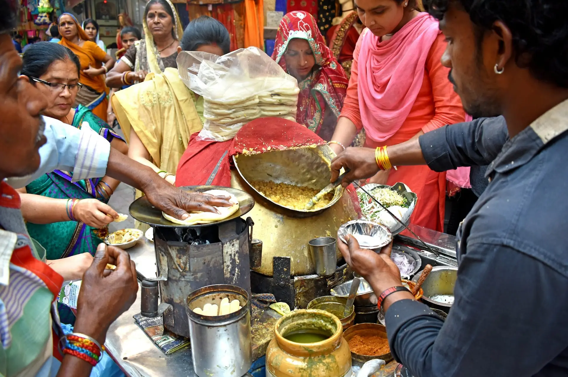 Cooks frying snacks at a busy street-food stall in Old Delhi