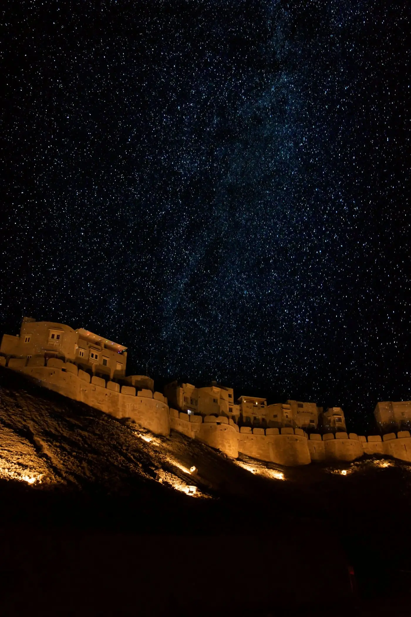 A desert night sky full of stars above an old sandstone structure near Jaisalmer
