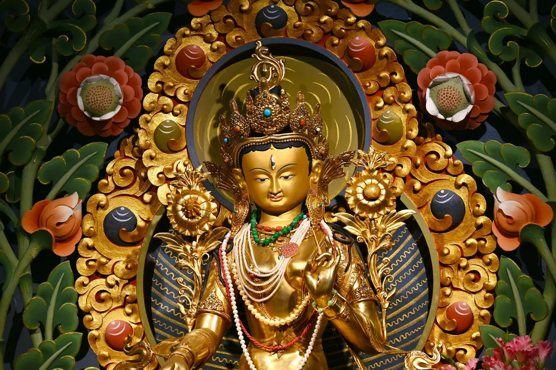 A golden Buddhist statue surrounded by offerings at Gonjang Monastery